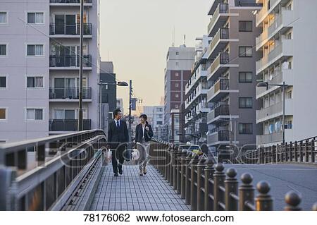 Japanese couple walking home from work View Large Photo Image Stock Image - Japanese couple walking home from work. Fotosearch