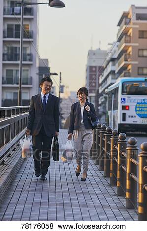 Stock Photo - Japanese couple walking home from work. Fotosearch