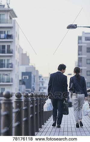 Stock Photo - Japanese couple walking home from work. Fotosearch