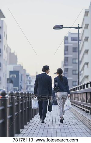 Stock Photo - Japanese couple walking home from work. Fotosearch