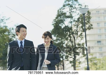 Stock Image - Japanese couple walking to work. Fotosearch
