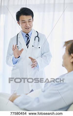 Japanese doctor with a patient in bed View Large Photo Image Picture - Japanese doctor with a patient in bed. Fotosearch