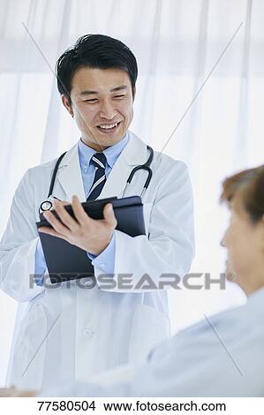 Japanese doctor with a patient in bed View Large Photo Image Picture - Japanese doctor with a patient in bed. Fotosearch