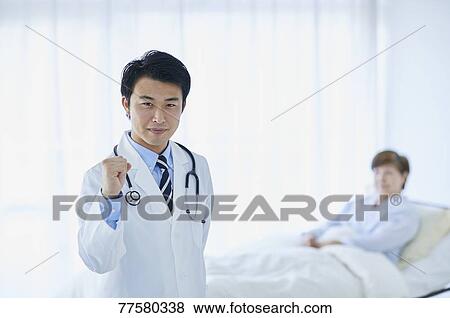 Stock Photo - Japanese doctor with a patient in bed. Fotosearch
