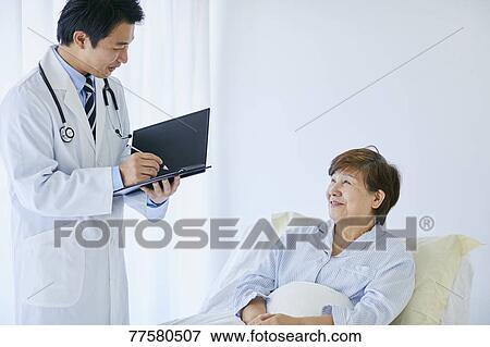 Japanese doctor with a patient in bed View Large Photo Image Stock Photo - Japanese doctor with a patient in bed. Fotosearch