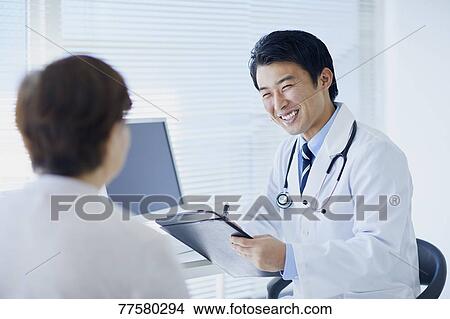 Picture - Japanese doctor with a patient in his studio. Fotosearch