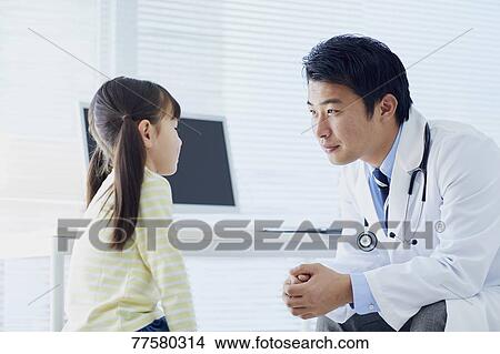 Picture - Japanese doctor with a patient in his studio. Fotosearch