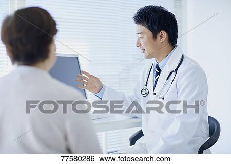 Japanese doctor with a patient in his studio View Large Photo Image Stock Photograph - Japanese doctor with a patient in his studio. Fotosearch