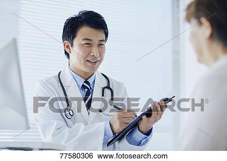 Stock Photograph - Japanese doctor with a patient in his studio. Fotosearch