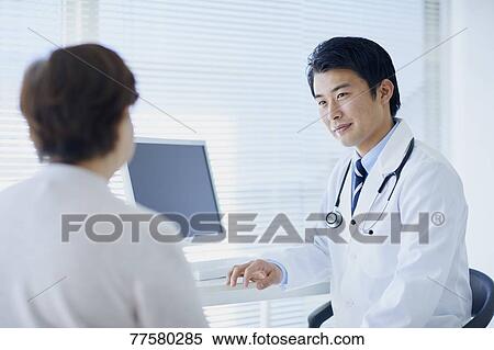 Stock Photography - Japanese doctor with a patient in his studio. Fotosearch