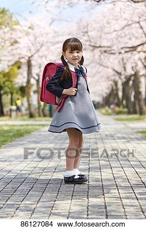 Japanese elementary schoolgirl and cherry blossoms View Large Photo Image Picture - Japanese elementary schoolgirl and cherry blossoms. Fotosearch