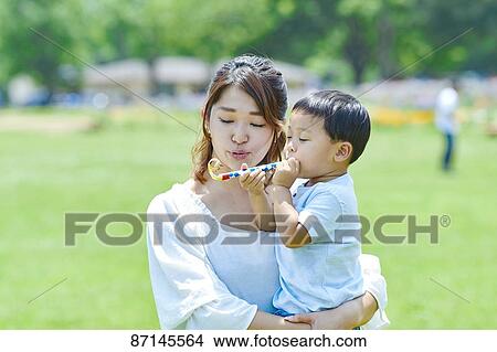 Picture - Japanese family in a city park. Fotosearch