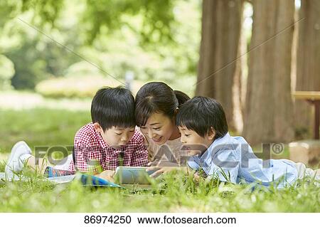 Stock Image - Japanese family in a city park. Fotosearch
