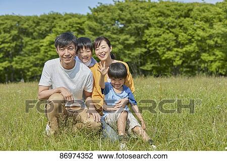 Stock Image - Japanese family in a city park. Fotosearch