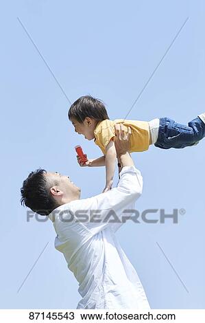 Stock Image - Japanese family in a city park. Fotosearch