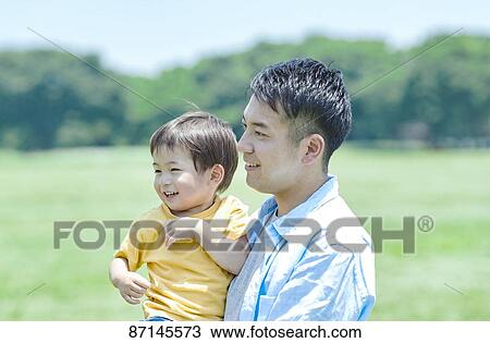 Stock Image - Japanese family in a city park. Fotosearch
