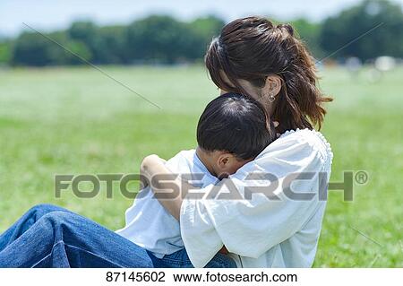 Stock Image - Japanese family in a city park. Fotosearch