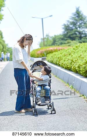 Stock Image - Japanese family in a city park. Fotosearch