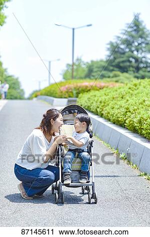 Stock Image - Japanese family in a city park. Fotosearch
