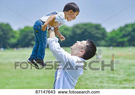 Stock Image - Japanese family in a city park. Fotosearch