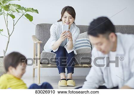 Stock Image - Japanese family in the living room. Fotosearch