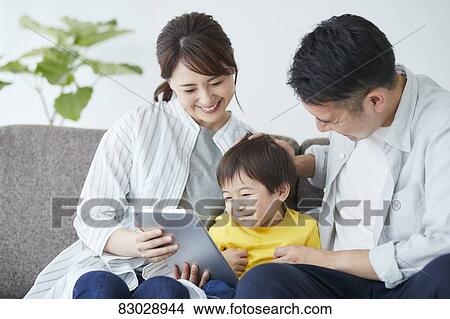 Picture - Japanese family on the sofa. Fotosearch