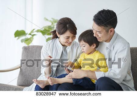 Stock Photo - Japanese family on the sofa. Fotosearch
