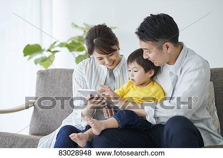 Stock Photo - Japanese family on the sofa. Fotosearch