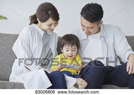 Stock Photograph - Japanese family on the sofa. Fotosearch