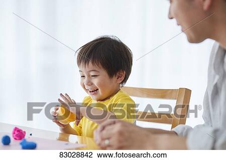 Stock Image - Japanese father and kid playing. Fotosearch