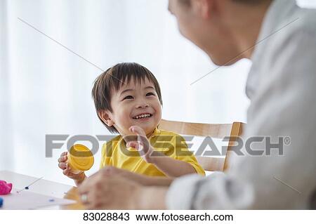 Stock Image - Japanese father and kid playing. Fotosearch