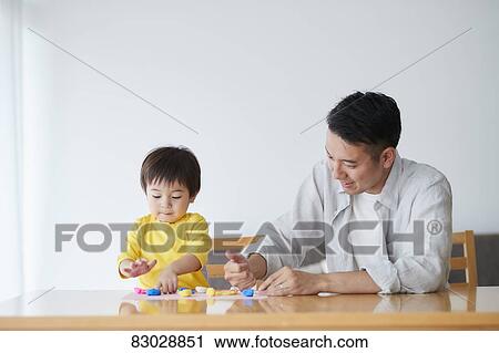 Stock Image - Japanese father and kid playing. Fotosearch