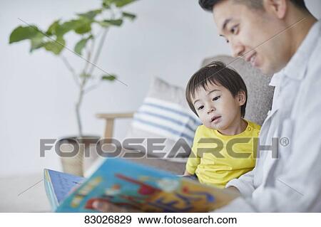 Japanese father and kid reading on the sofa View Large Photo Image Stock Photo - Japanese father and kid reading on the sofa. Fotosearch