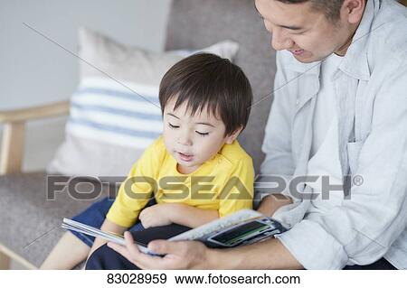 Japanese father and kid reading on the sofa View Large Photo Image Stock Photo - Japanese father and kid reading on the sofa. Fotosearch