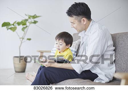 Japanese father and kid reading on the sofa View Large Photo Image Stock Photograph - Japanese father and kid reading on the sofa. Fotosearch