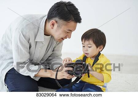 Picture - Japanese father and kid taking pictures. Fotosearch