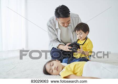 Stock Image - Japanese father and kid taking pictures. Fotosearch