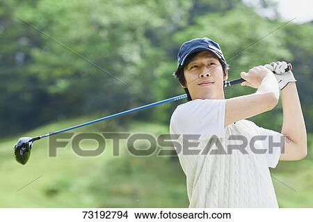 Picture - Japanese golf player on course. Fotosearch