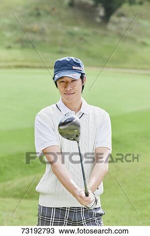 Stock Image - Japanese golf player on course. Fotosearch