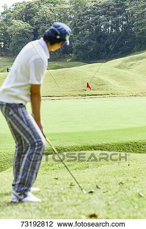 Stock Image - Japanese golf player on course. Fotosearch