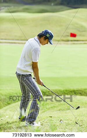 Stock Image - Japanese golf player on course. Fotosearch