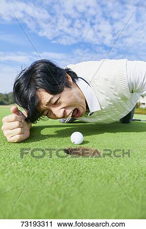 Stock Image - Japanese golf player on course. Fotosearch