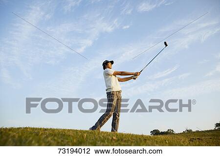 Stock Image - Japanese golf player on course. Fotosearch
