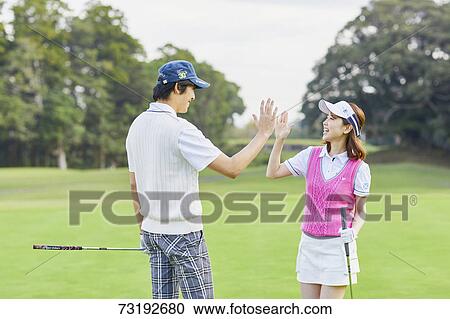 Stock Image - Japanese golf players on course. Fotosearch