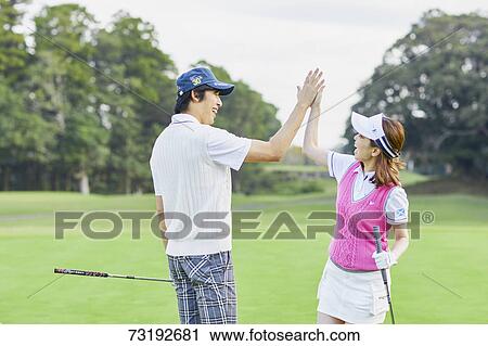 Stock Image - Japanese golf players on course. Fotosearch