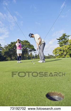 Stock Image - Japanese golf players on course. Fotosearch