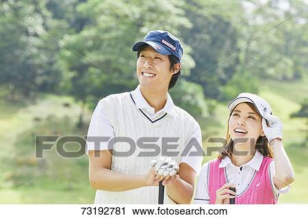 Stock Image - Japanese golf players on course. Fotosearch