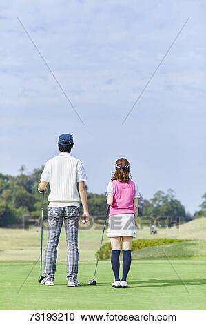 Stock Image - Japanese golf players on course. Fotosearch