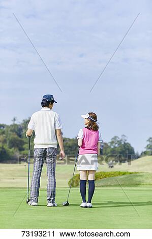 Stock Image - Japanese golf players on course. Fotosearch