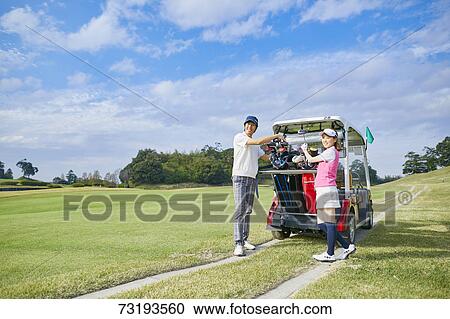 Stock Image - Japanese golf players on course. Fotosearch